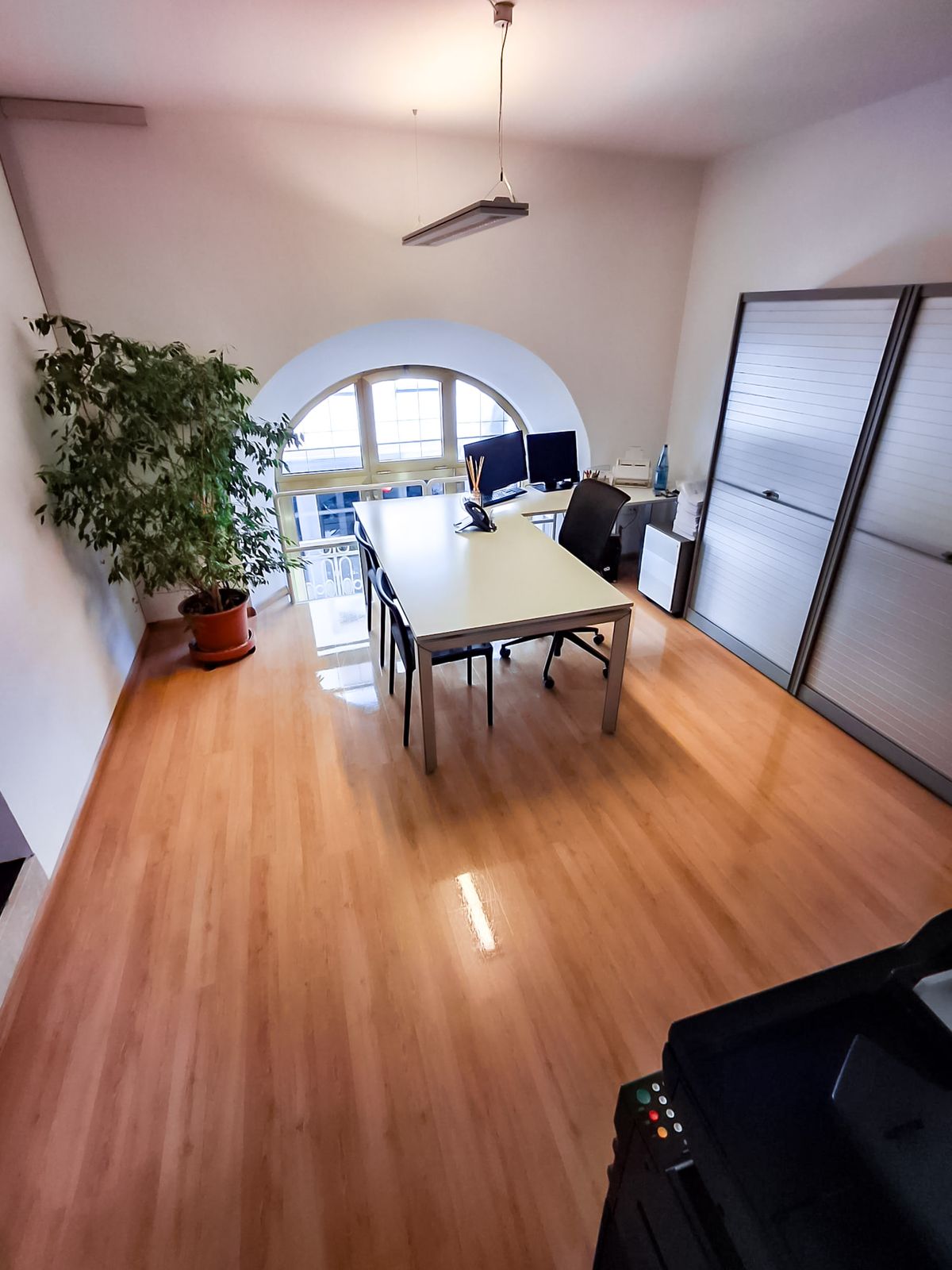 Ufficio pulito con finestra ad arco e parquet